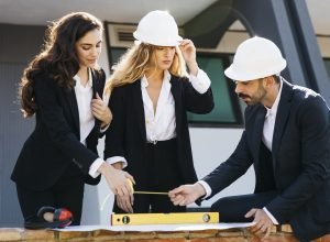 architects wearing helmets with level